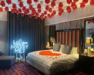 marriage proposal with balloons and petals in a hotel