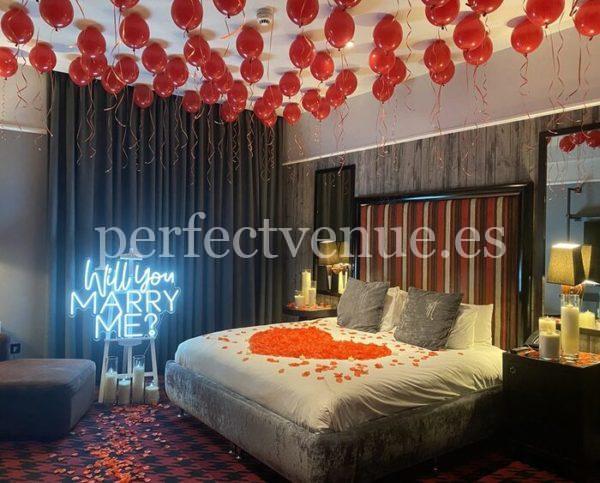 marriage proposal with balloons and petals in a hotel