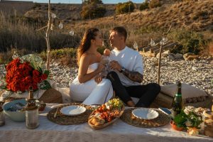 marriage proposal with a picnic and petals in the beach - Photo via Weddings and Events by Natalia Ortiz