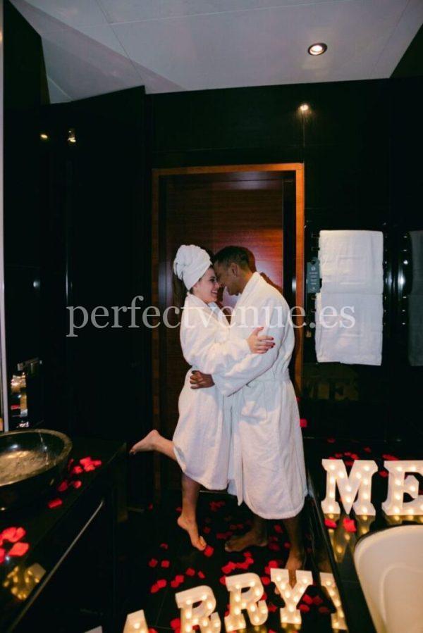 Marriage proposal in a hotel with marry me letters and petals Natalia Ortiz