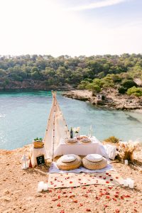 Picnic on the beach with romantic decoration / Photo via Natalia Ortiz Events