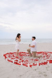 Una pedida de mano en Murcia con corazón de pétalos de rosa en la playa