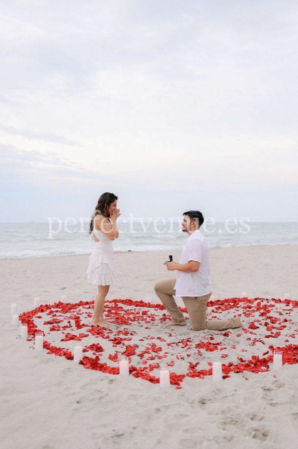 Una pedida de mano en Murcia con corazón de pétalos de rosa en la playa