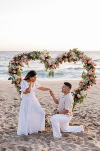 A marriage proposal in Cadiz with a large flower heart on the beach / Photo via Natalia Ortiz Events