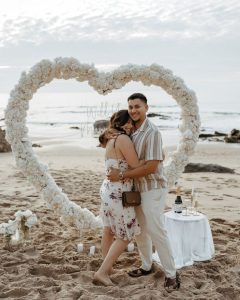 A marriage proposal in Cadiz with a large flower heart on the beach / Photo via Natalia Ortiz Events
