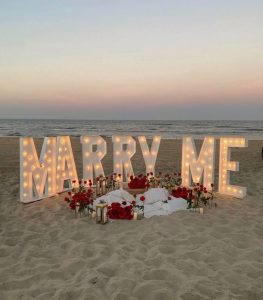 A marriage proposal in Malaga with illuminated “MARRY ME” letters