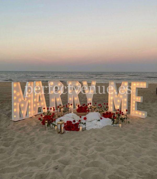 A marriage proposal in Malaga with illuminated “MARRY ME” letters