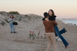 Beach proposal with roses and "Marry Me" lettering / Photo via Natalia Ortiz Events